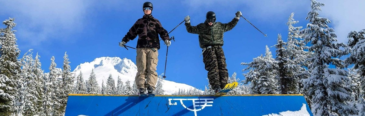 Two skiers on a rail in Conway's with Mt. Hood in the background