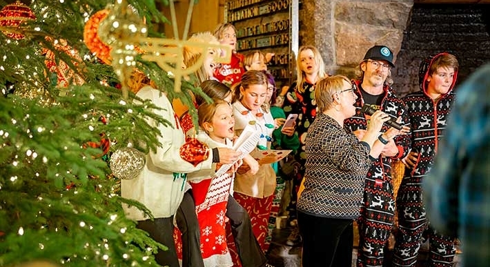 GUESTS SINGING CHRISTMAS CAROLS AT TIMBERLINE'S TREE LIGHTING EVENT