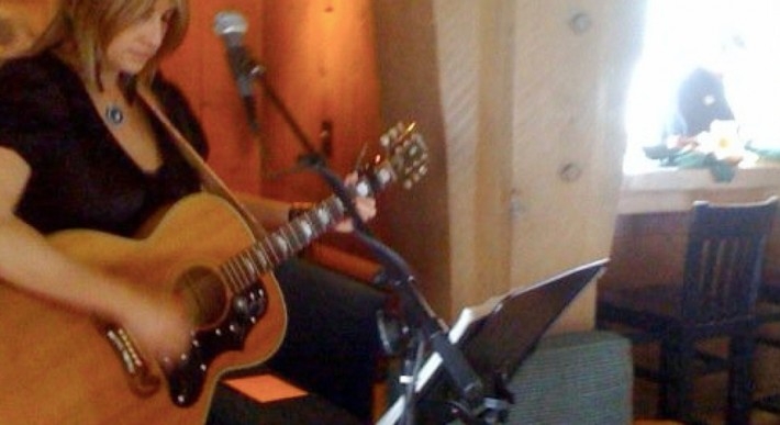 Musician Gayle Ritt playing guitar at the Ram's Head Bar