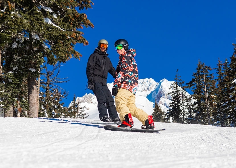 TWO SNOWBOARDERS RIDING AT TIMBERLINE