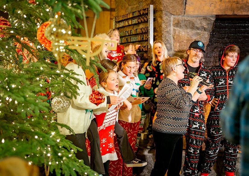 GUESTS GATHERED IN THE TIMBERLINE HEADHOUSE SINGING CHRISTMAS CAROLS