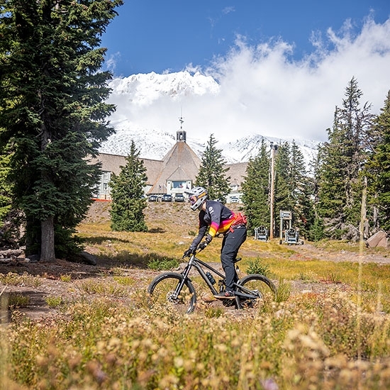 MOUNTAIN BIKER RIDING IN FRONT OF TIMBERLINE LODGE