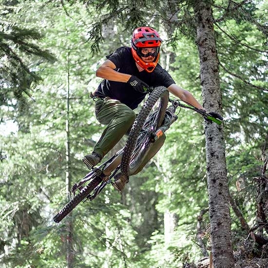 MOUNTAIN BIKER JUMPING IN THE FOREST AT THE TIMBERLINE BIKE PARK