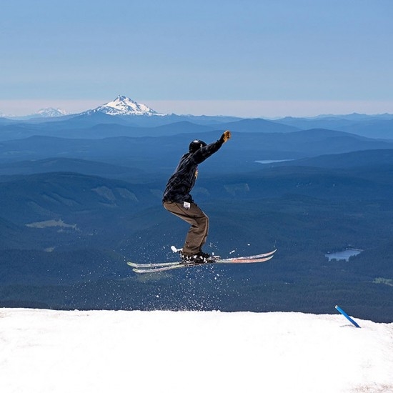 FREESTYLE SKIER LANDING A JUMP AT TIMBERLINE SUMMER SNOW CAMP