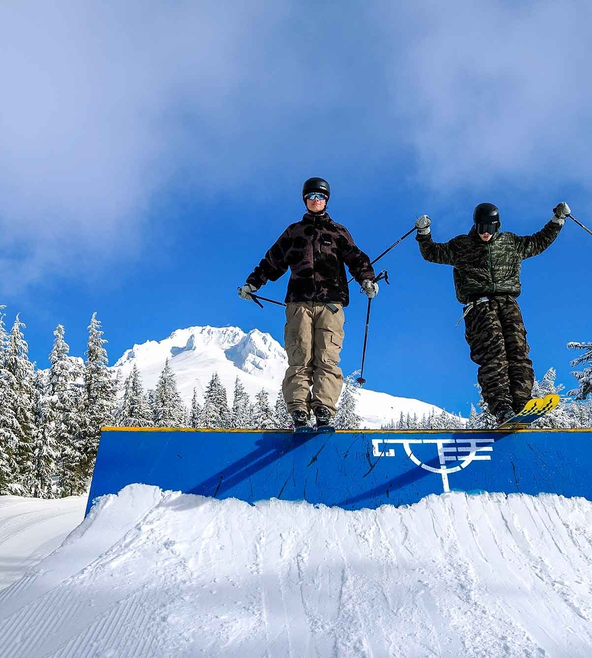 Two skiers on a feature at Timberline Lodge with Mt. Hood in the background