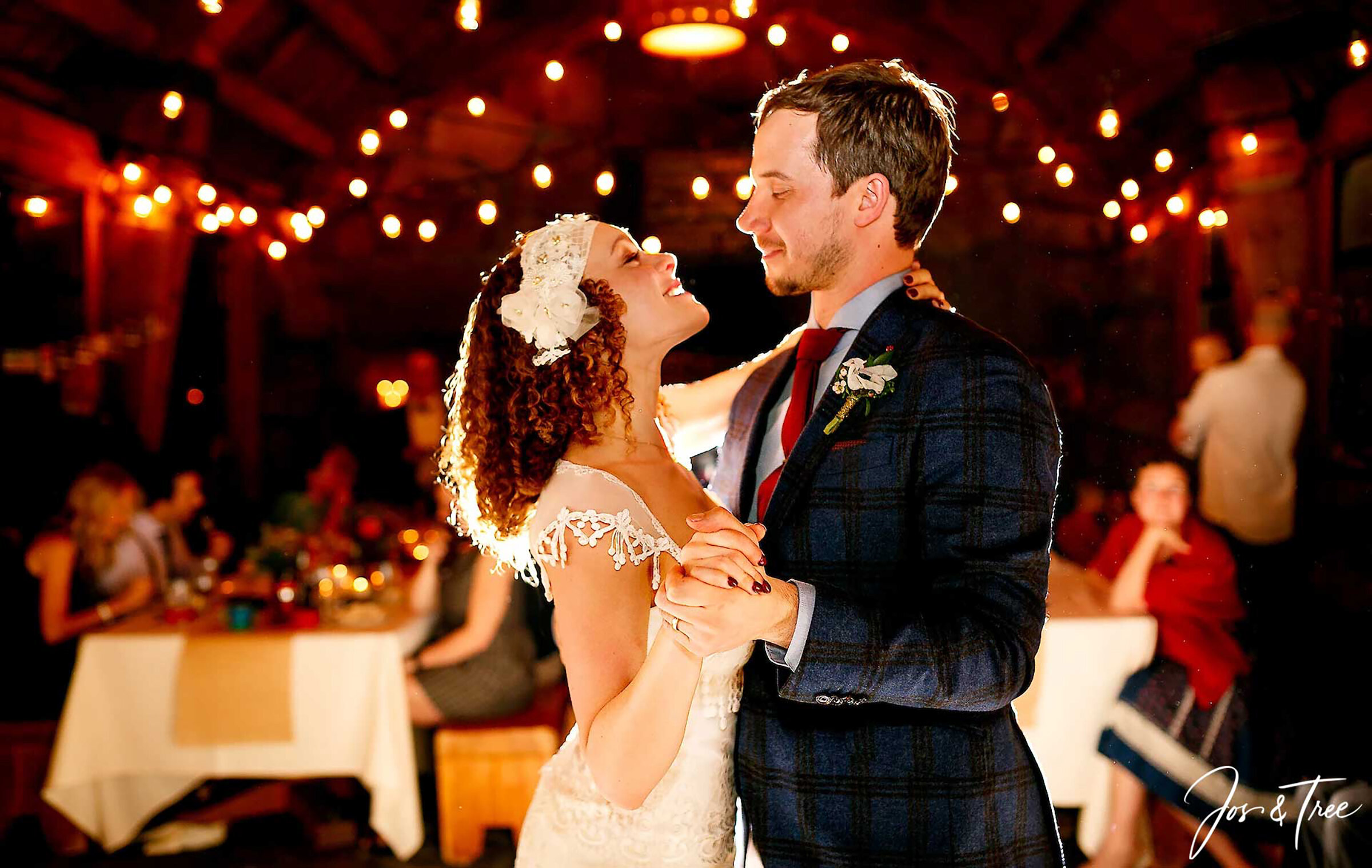 A bride and groom share their first dance inside Silcox Hut, surrounded by warm string lights and guests seated at nearby tables, creating a cozy and intimate mountain wedding atmosphere.