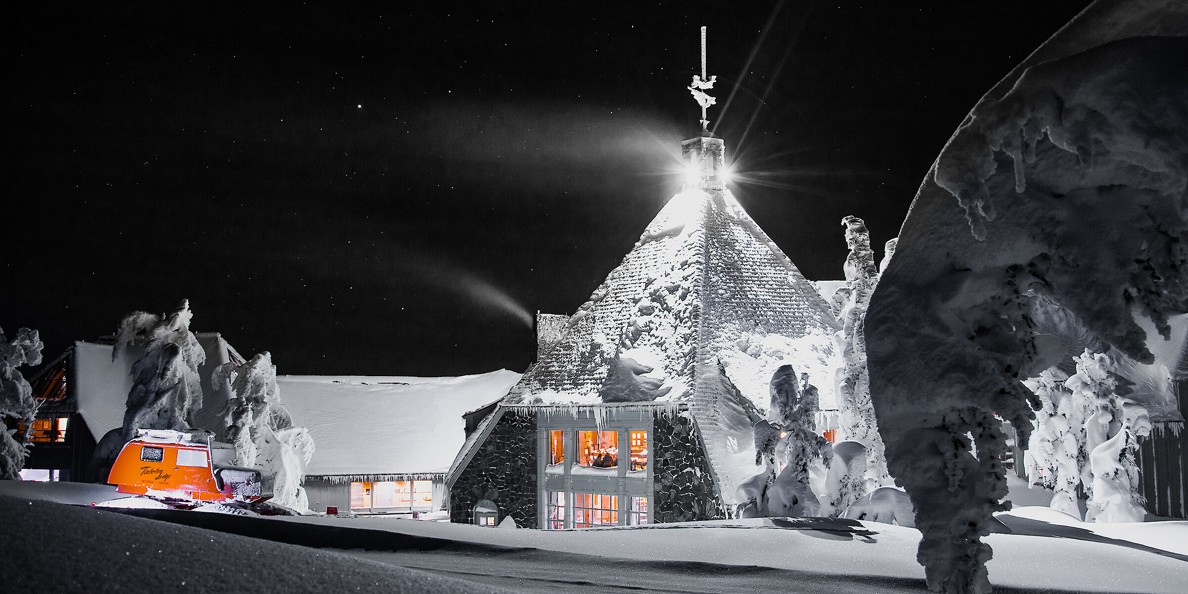 Timberline Lodge on Mt. Hood glowing under a starry winter night, surrounded by deep snow and illuminated by a bright full moon.