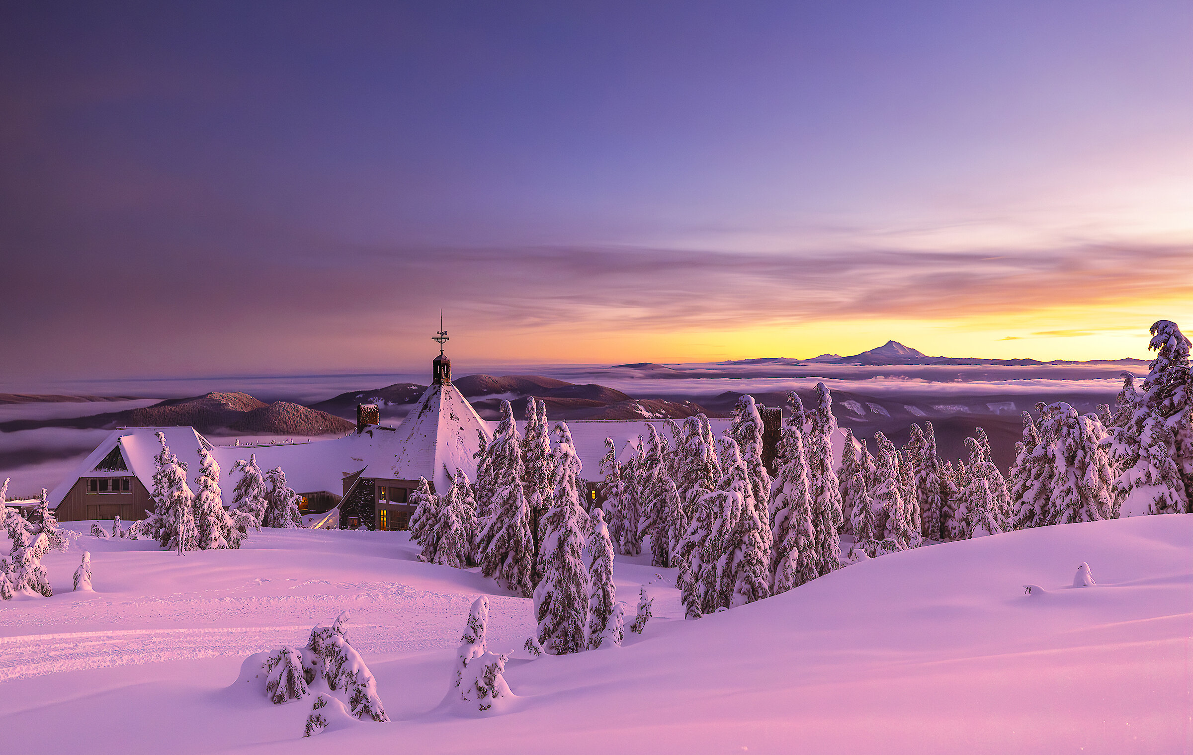 Snow-covered Timberline Lodge pictured at sunset overlooking Mt. Jefferson
