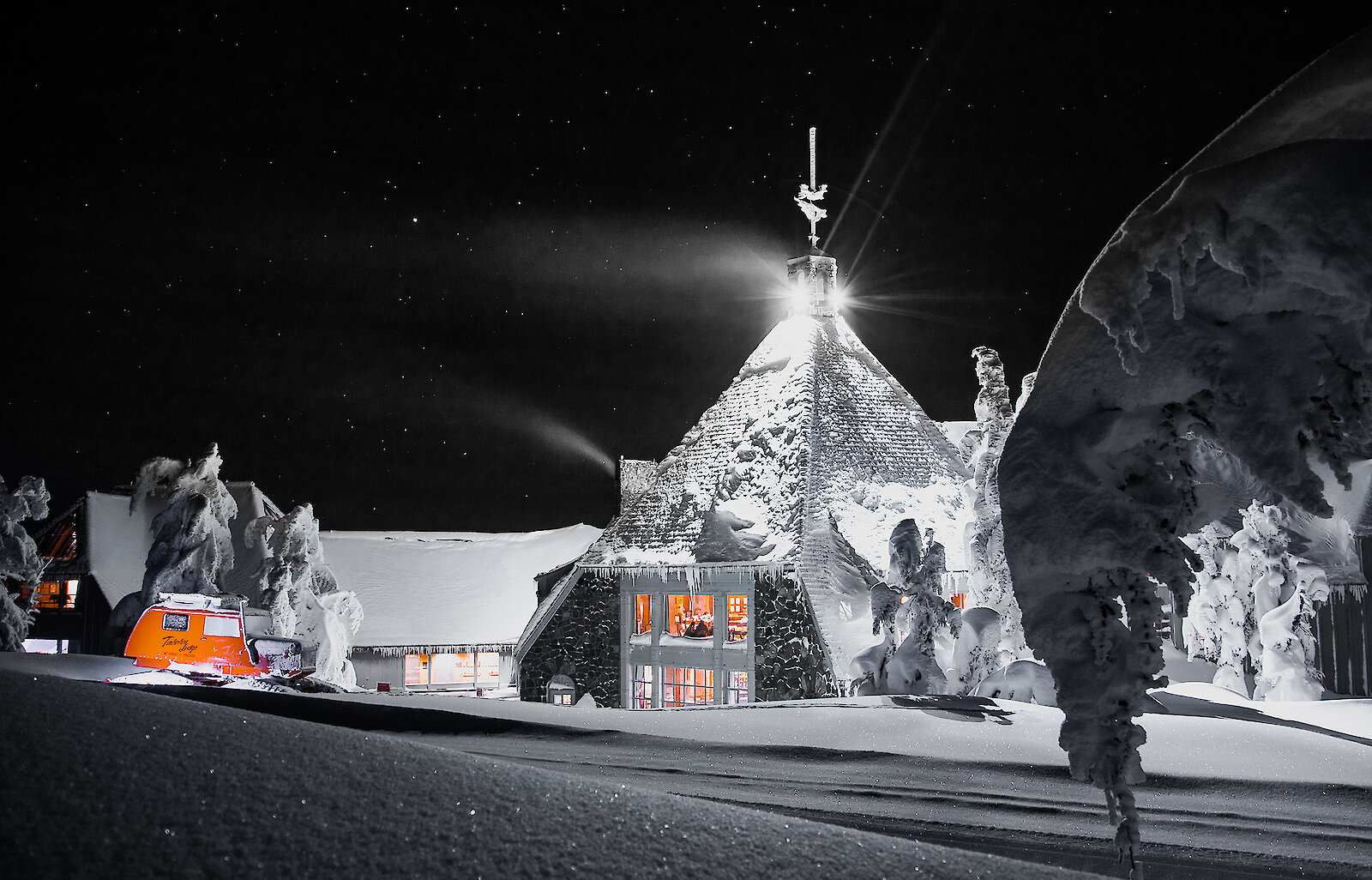Timberline Lodge on Mt. Hood glowing under a starry winter night, surrounded by deep snow and illuminated by a bright full moon.
