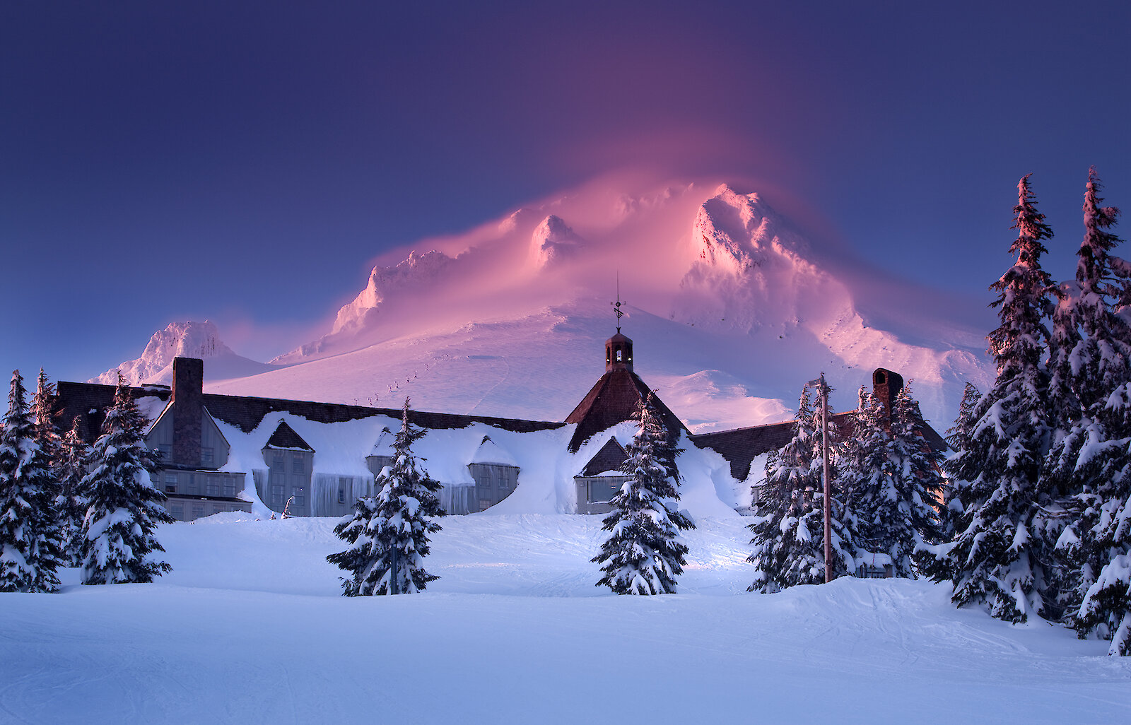 Winter sunrise at Timberline Lodge with Mount Hood glowing pink.
