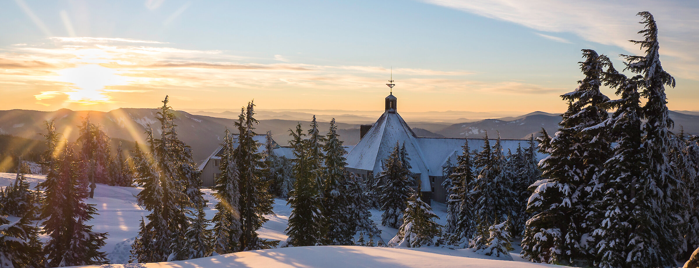 Timberline Lodge pictured from behind at sunrise in the winter