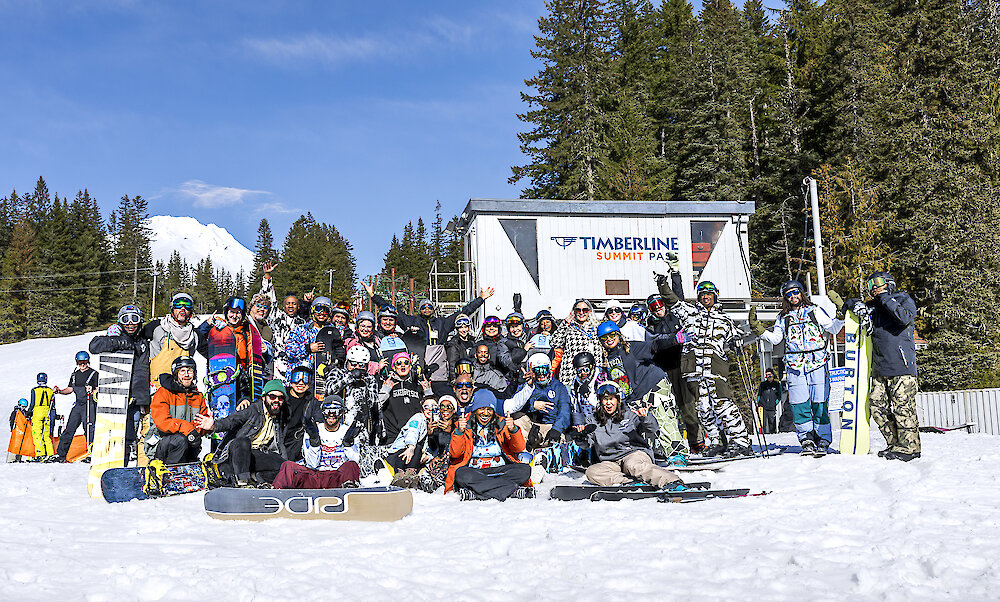Group of skiers and snowboarders gathered at Timberline Summit Pass on a beautiful winter day.