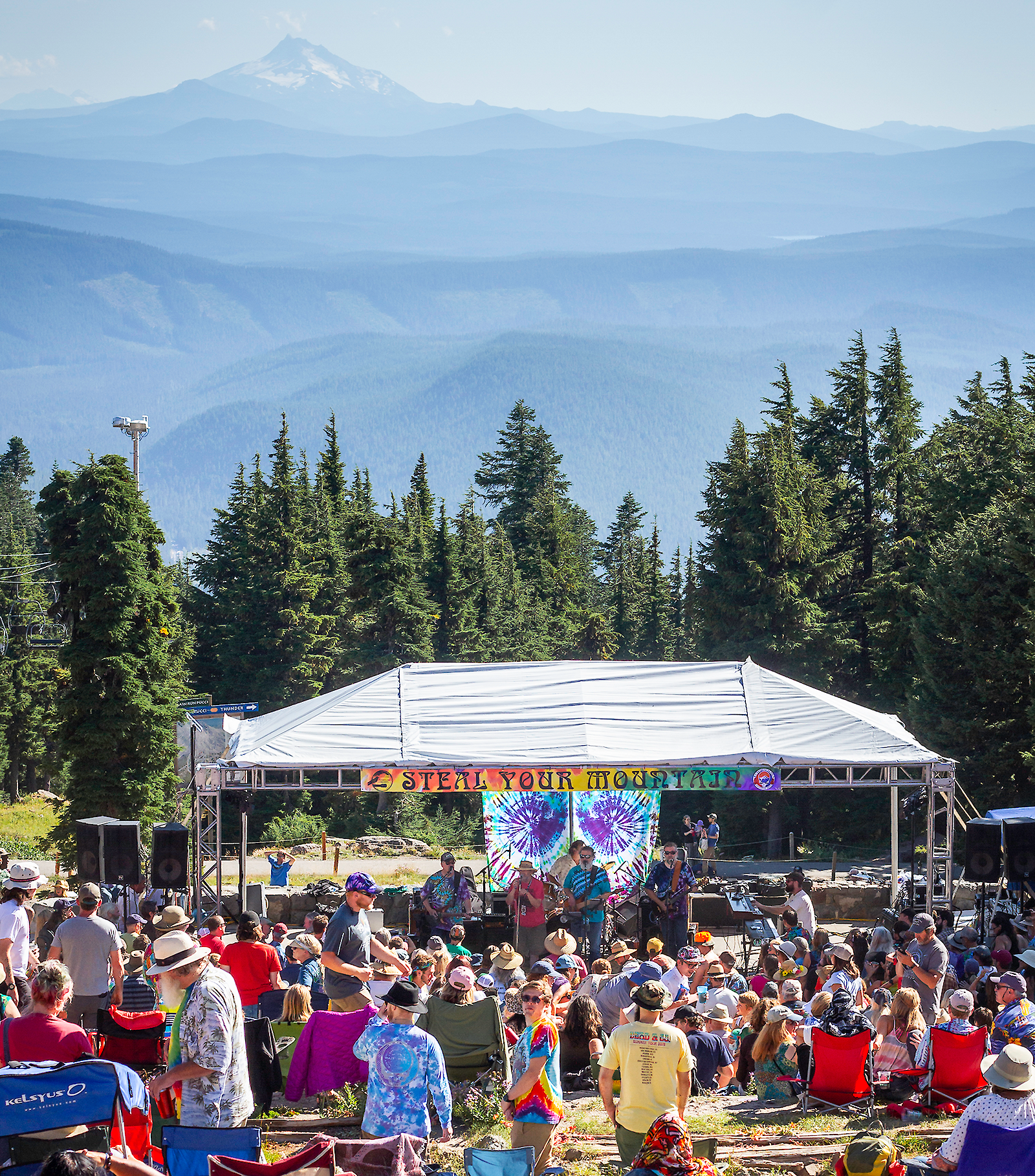Outdoor live music performance at Timberline Daydream with a crowd gathered in front of a stage, Mount Hood visible in the background.