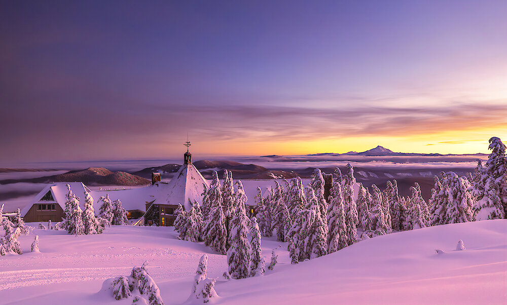Snow-covered Timberline Lodge pictured at sunset overlooking Mt. Jefferson