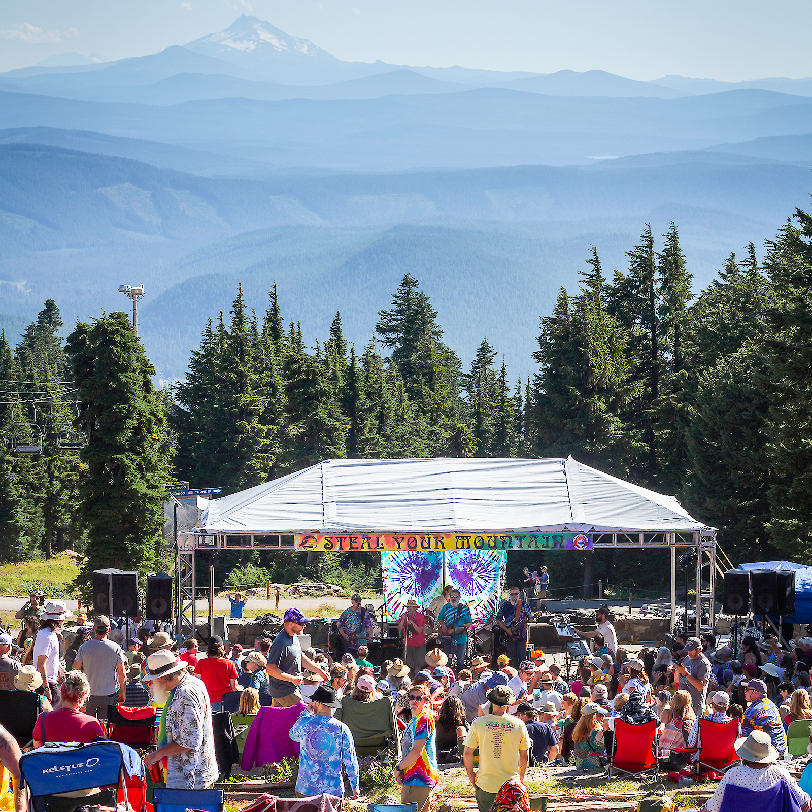 Outdoor live music performance at Timberline Daydream with a crowd gathered in front of a stage, Mount Hood visible in the background.