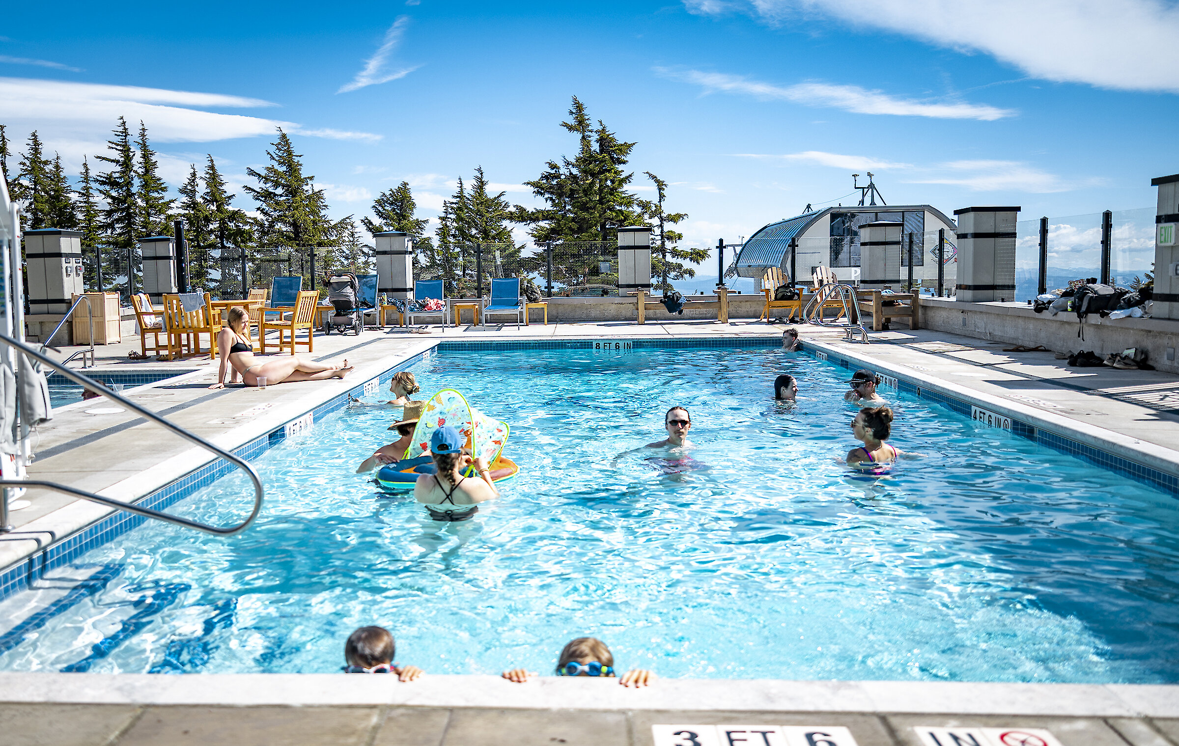 Kids and families enjoying the heated outdoor pool at Timberline on a sunny spring day