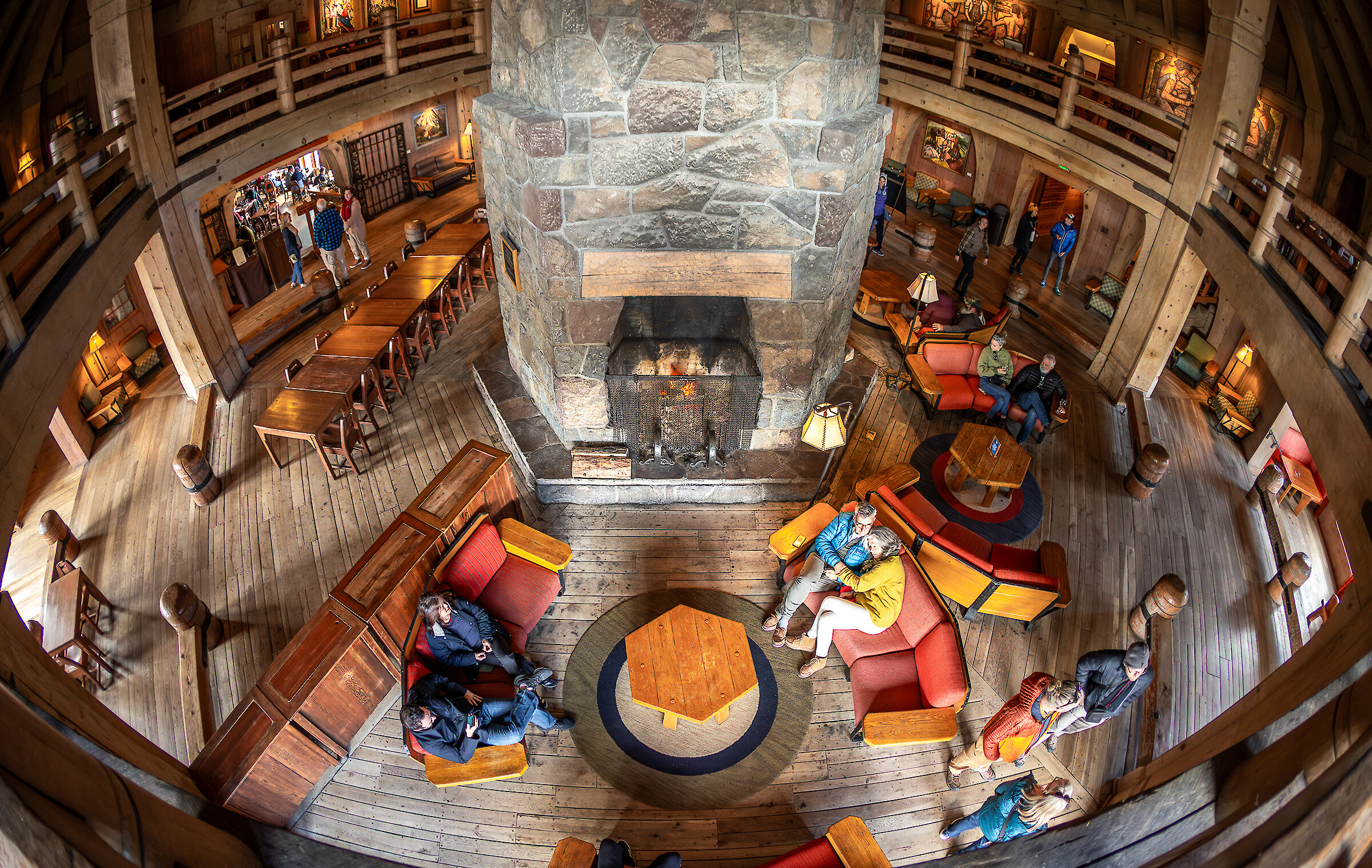 Guests relaxing on the couches around the fireplace in the Main Headhouse at Timberline