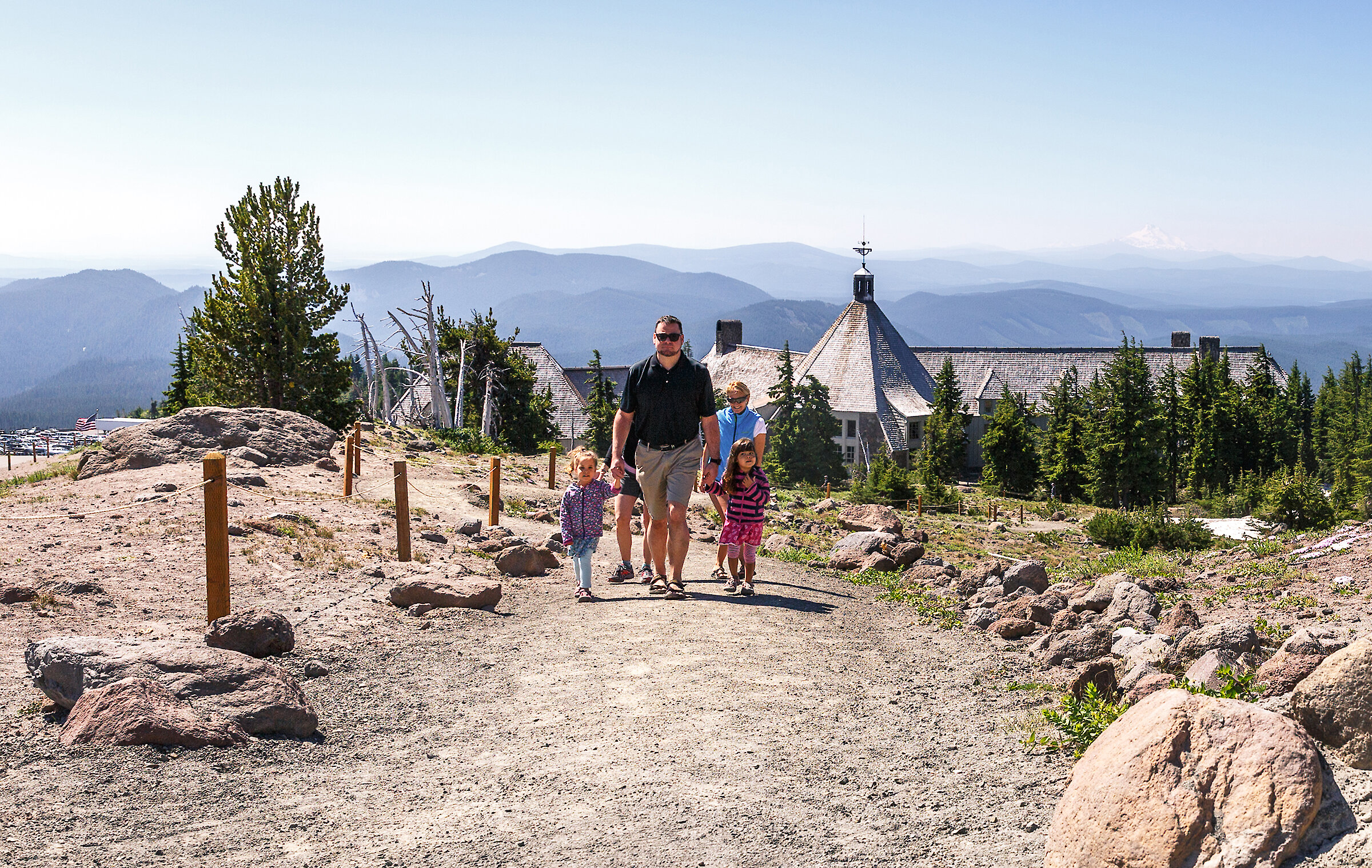 Family with two small kids hiking above Timberline Lodge with the Cascade showing in the background