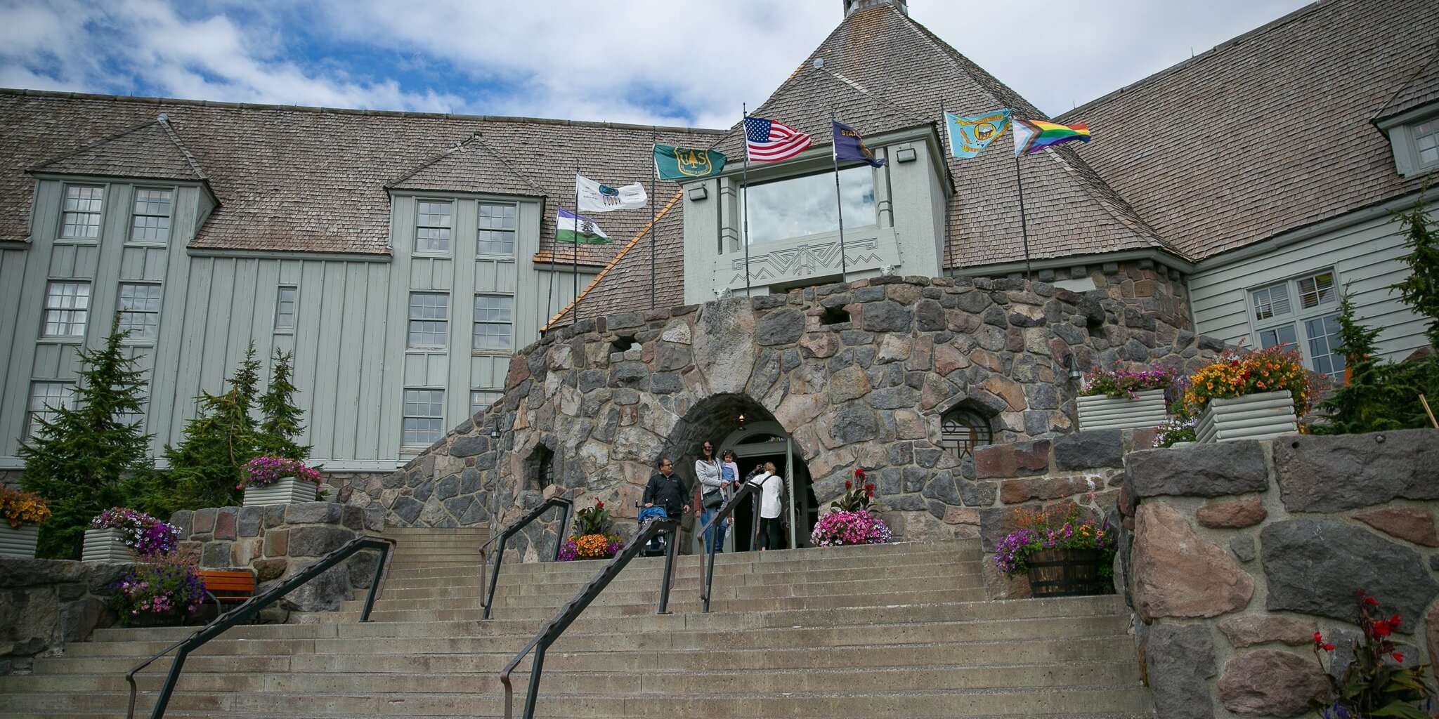 Front steps and entrance of Timberline Lodge with family standing in front