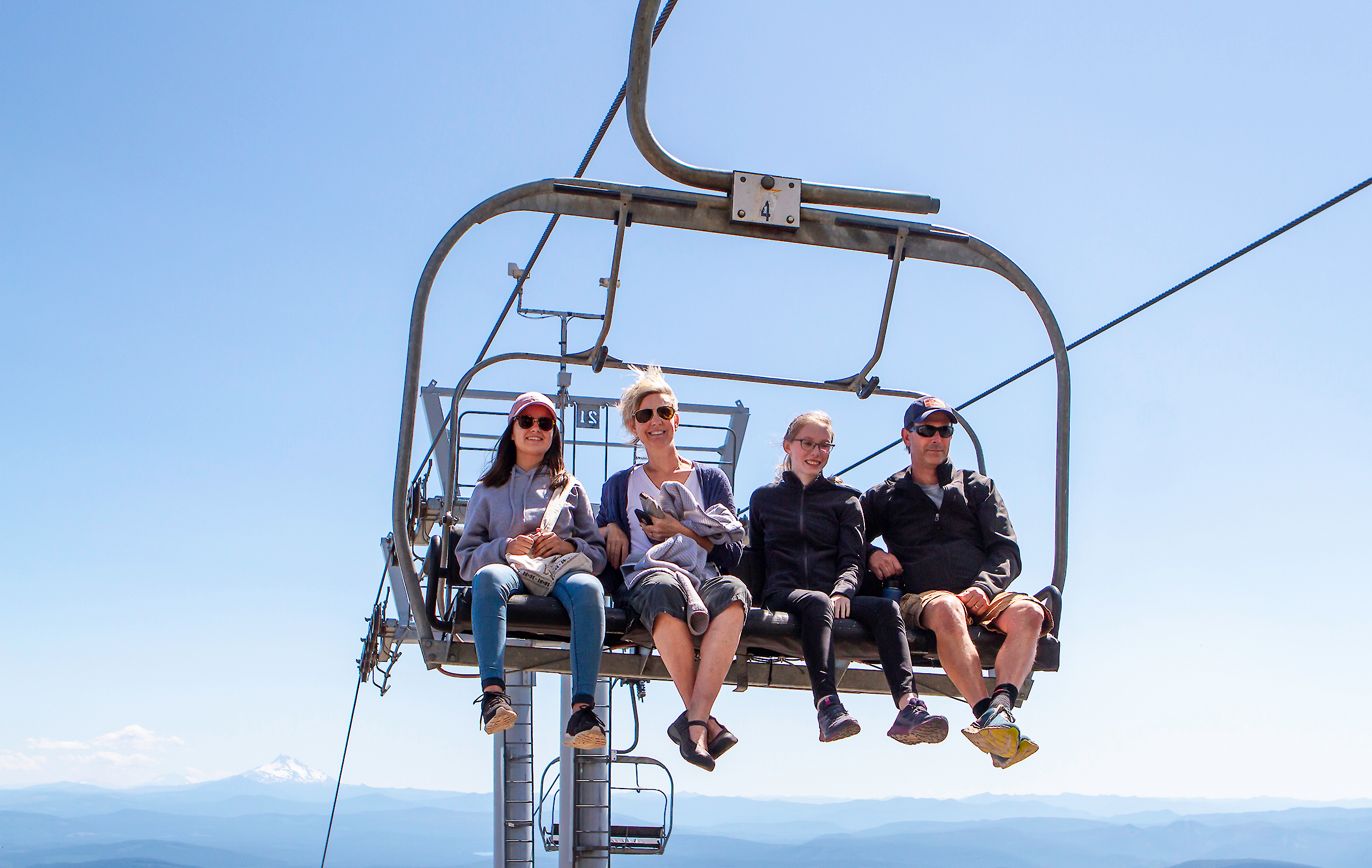 Family of four on the Magic Mile Sky Ride with blue skies all around them