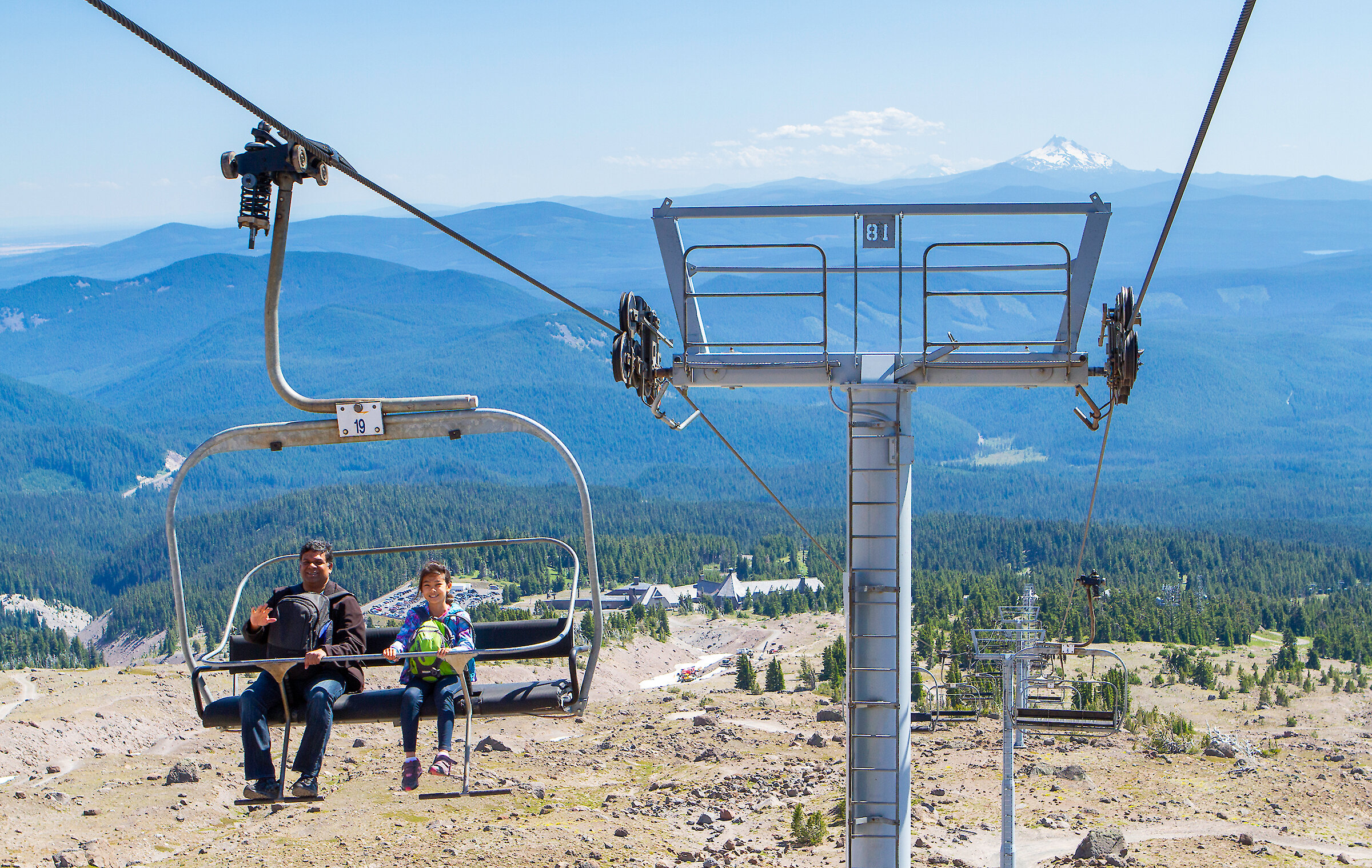 Dad and daughter enjoying the Magic Mile Sky Ride with Timberline the Cascade Range showing in the back groun