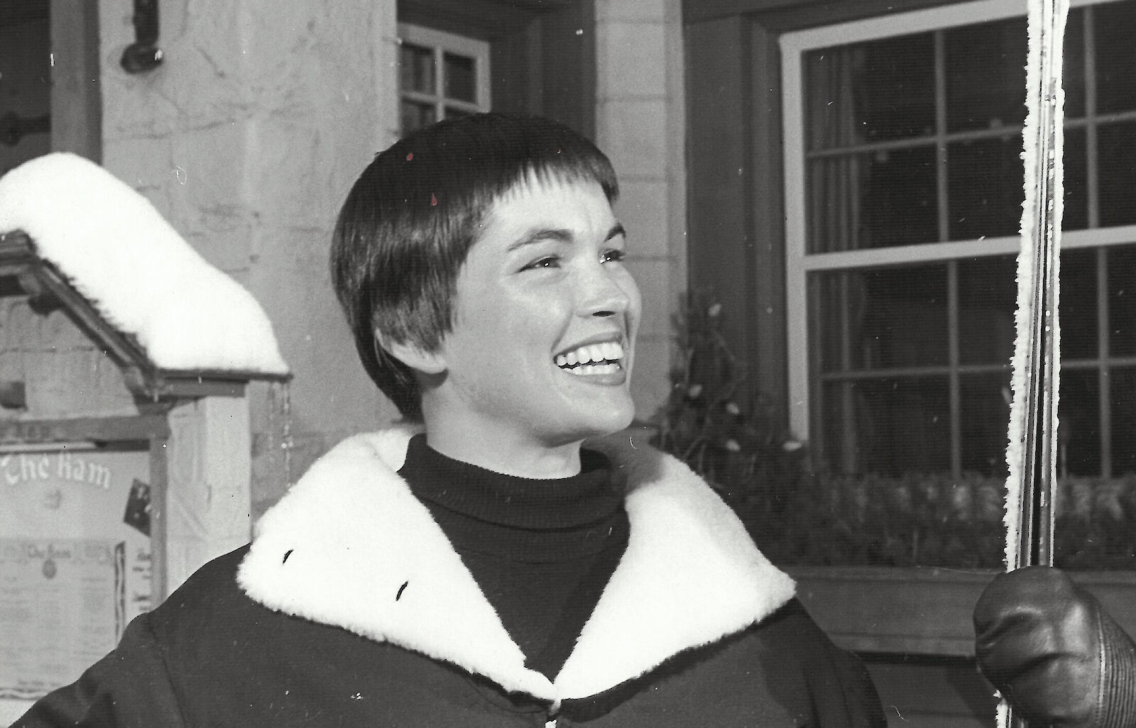 Picture of Molly Kohnstamm as a young woman in the 1960s dressed in ski gear and holding skis