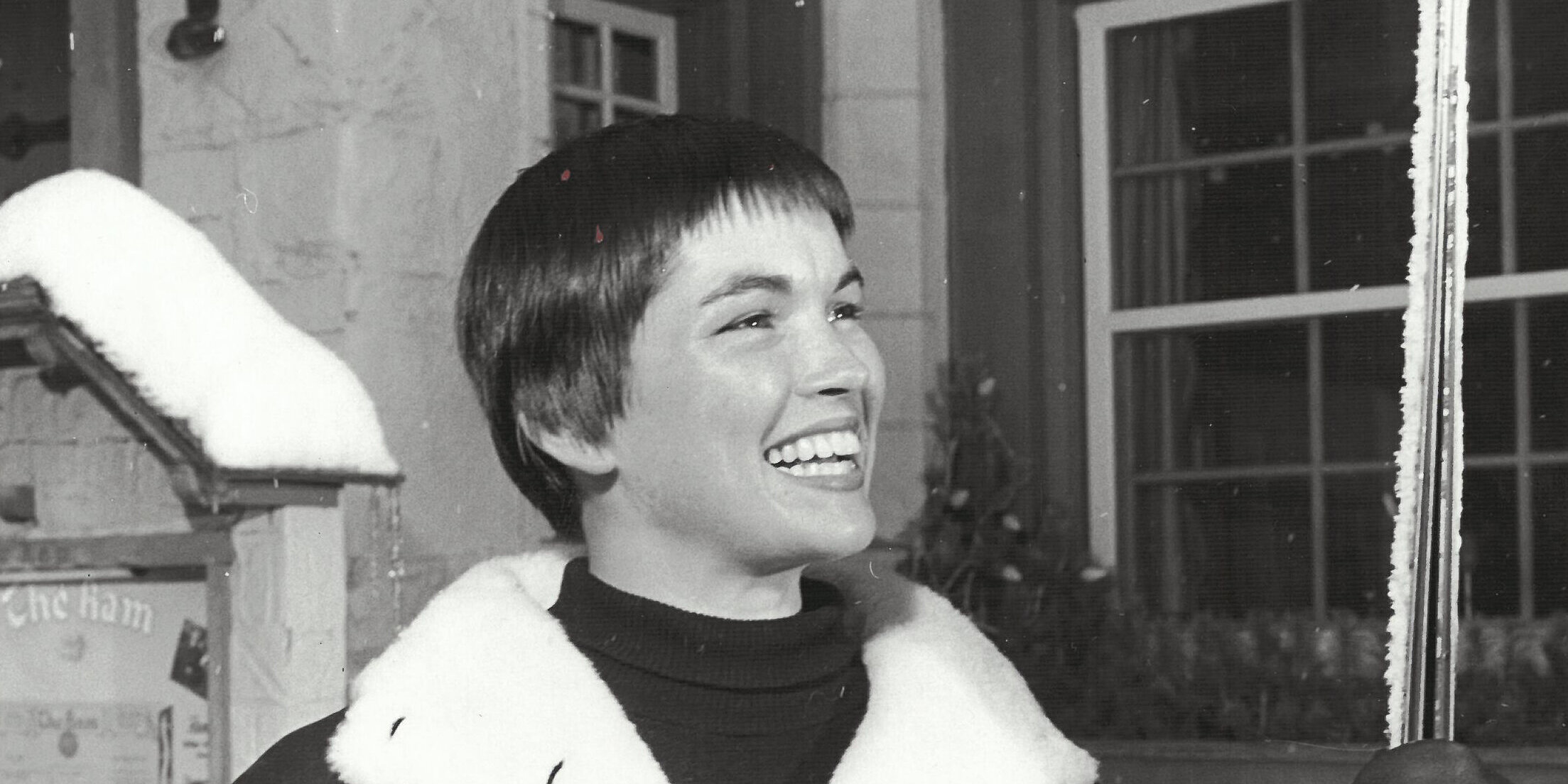 Picture of Molly Kohnstamm as a young woman in the 1960s dressed in ski gear and holding skis