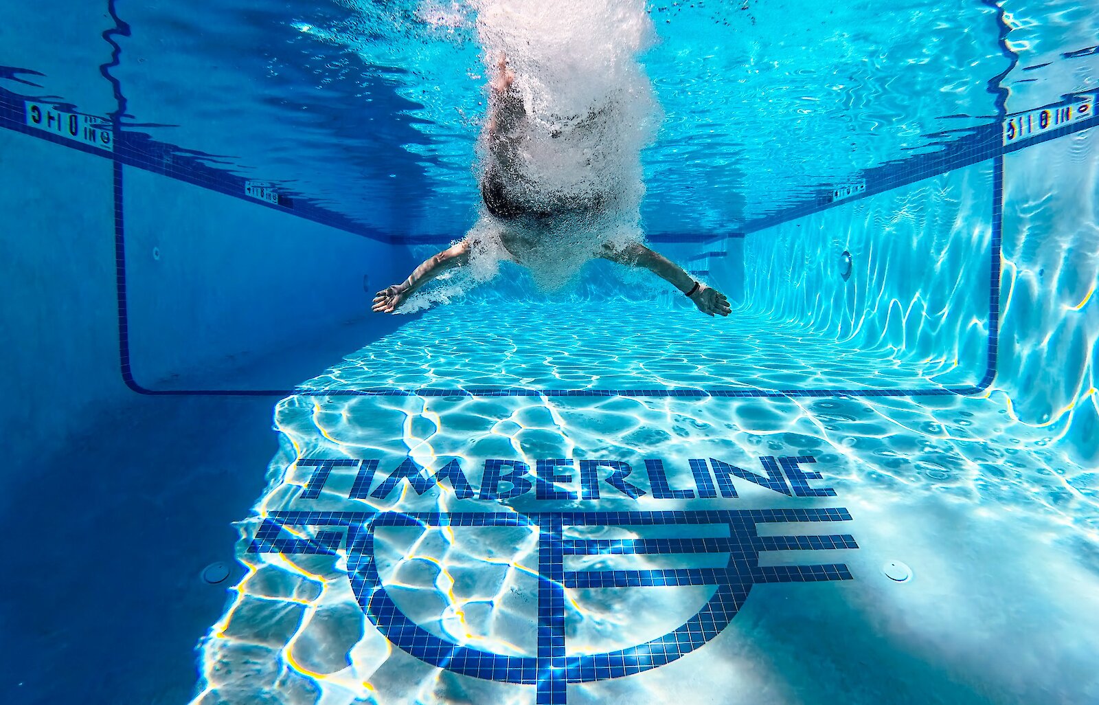 Guest featured mid-dive in the Timberline heated outdoor pool