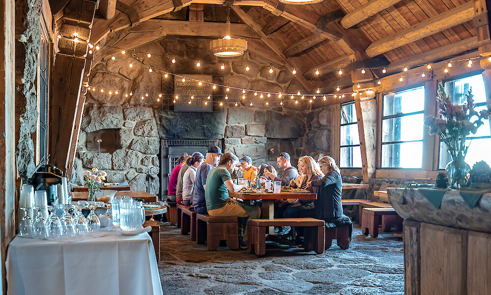 Group gathered around the dining table for dinner at Silcox Hut