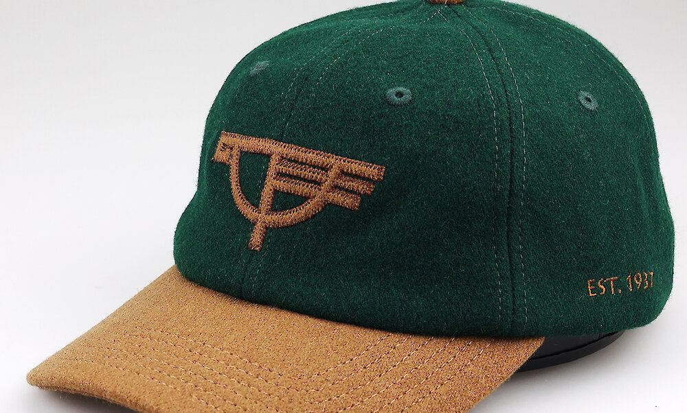 Green and gold wool baseball hat featuring the Timberline Snowgoose logo
