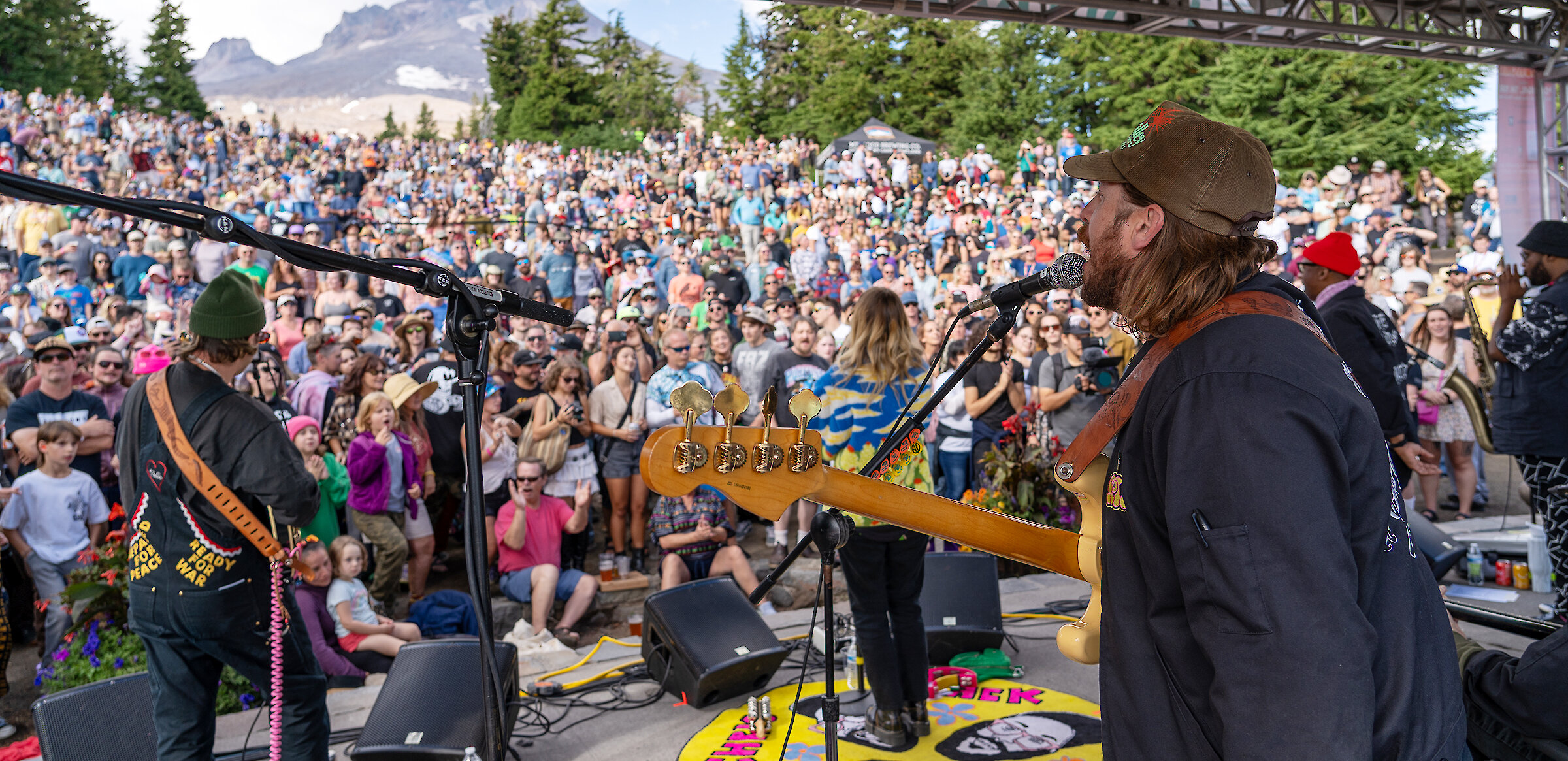 Timberline Daydream crowd enjoying a live outdoor concert at Mt. Hood with mountain views, summer festival atmosphere, and musicians performing on stage at Timberline Lodge.