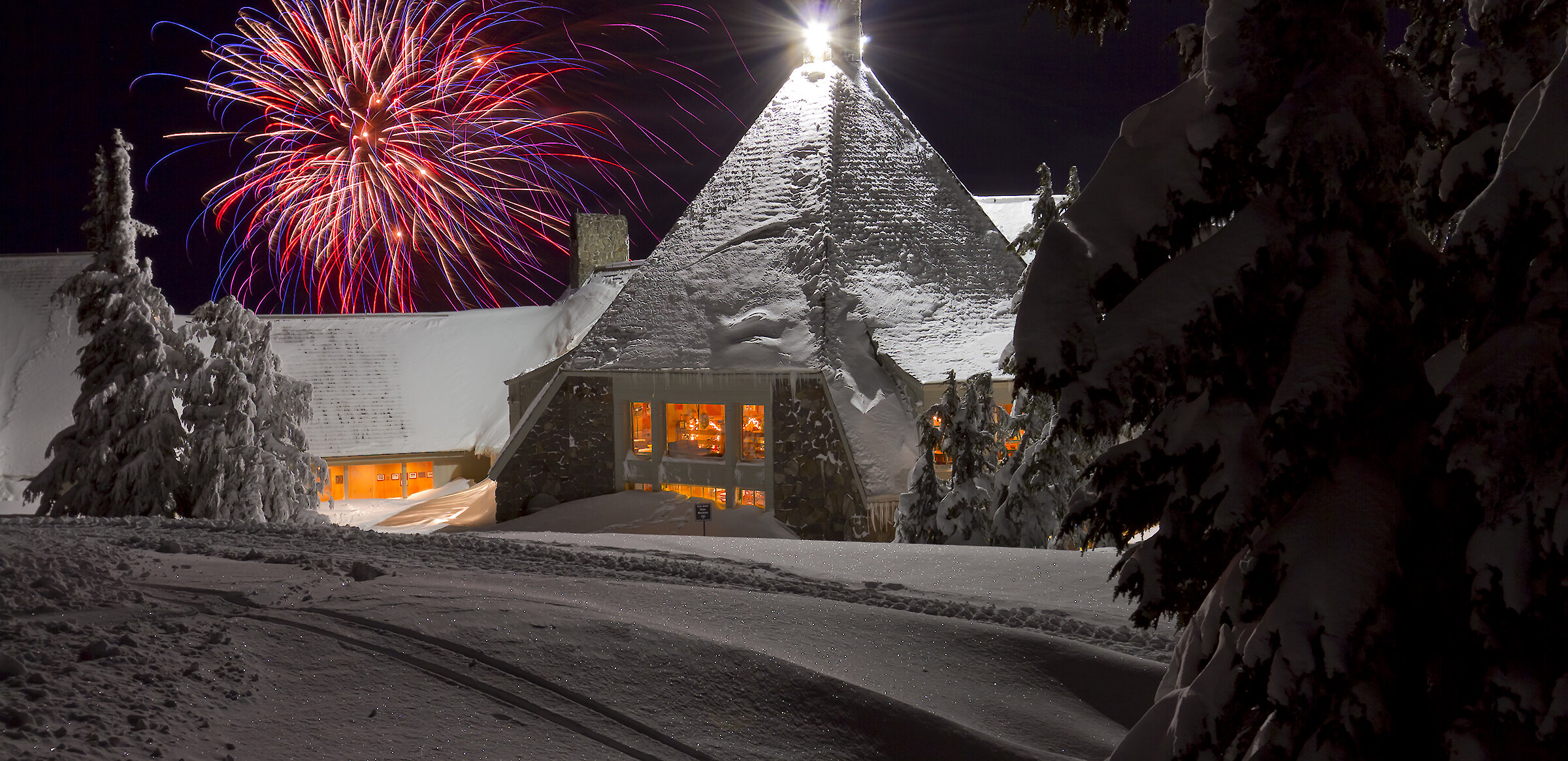 Fireworks going off in the snow at Timberline Lodge during New Year's Eve