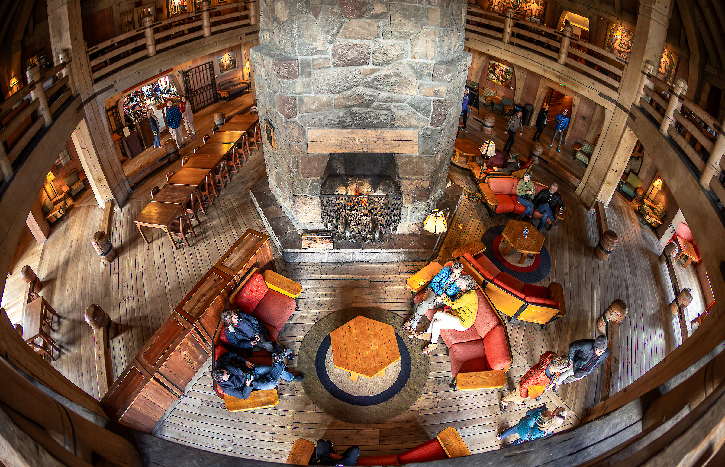Guests relaxing on the couches around the fireplace in the Main Headhouse at Timberline