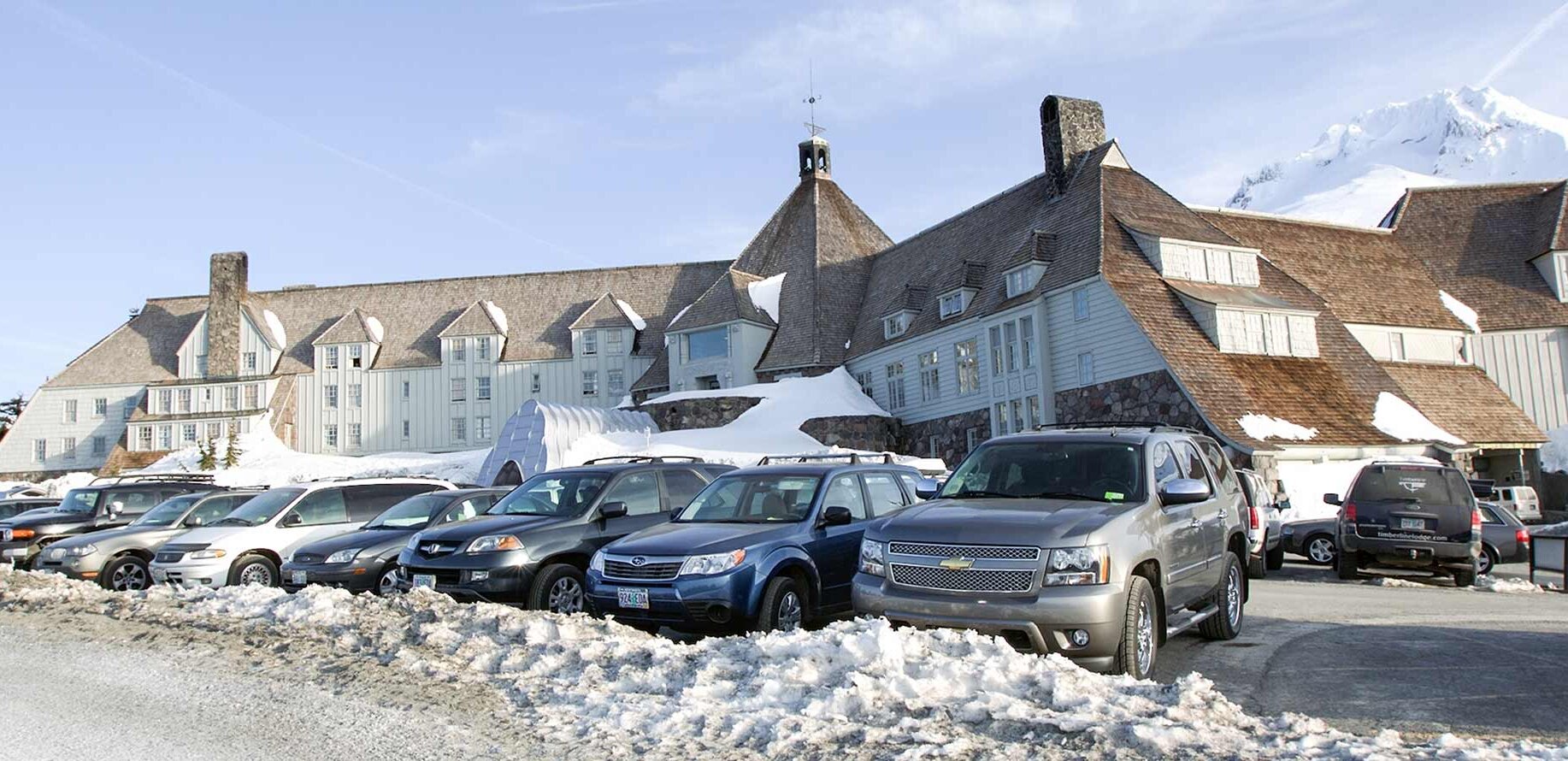 View of Timberline Lodge in the winter with cars in the foreground