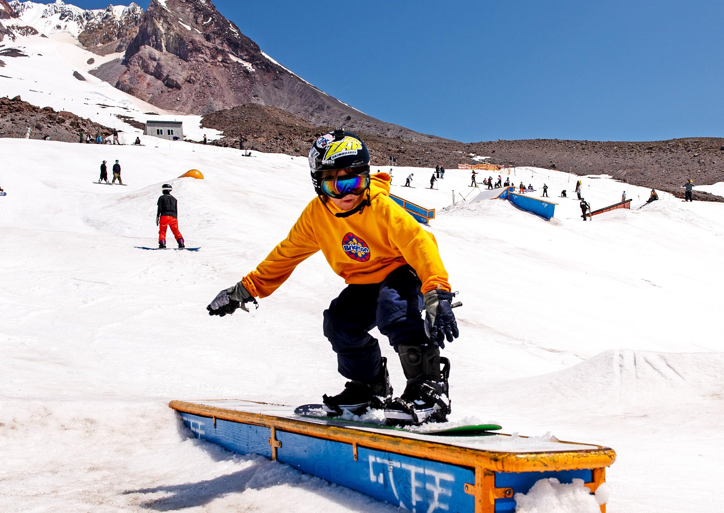 Youth snowboarder practicing on a box at Timberline Freestyle Camp on Mt. Hood