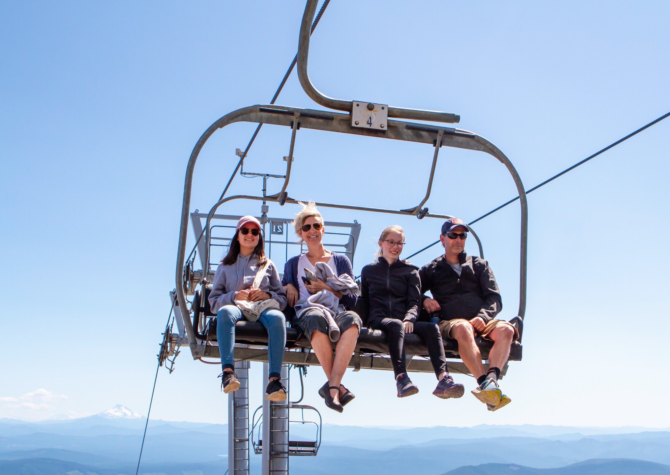 Family of four people riding the Magic Mile Sky Ride at Timberline