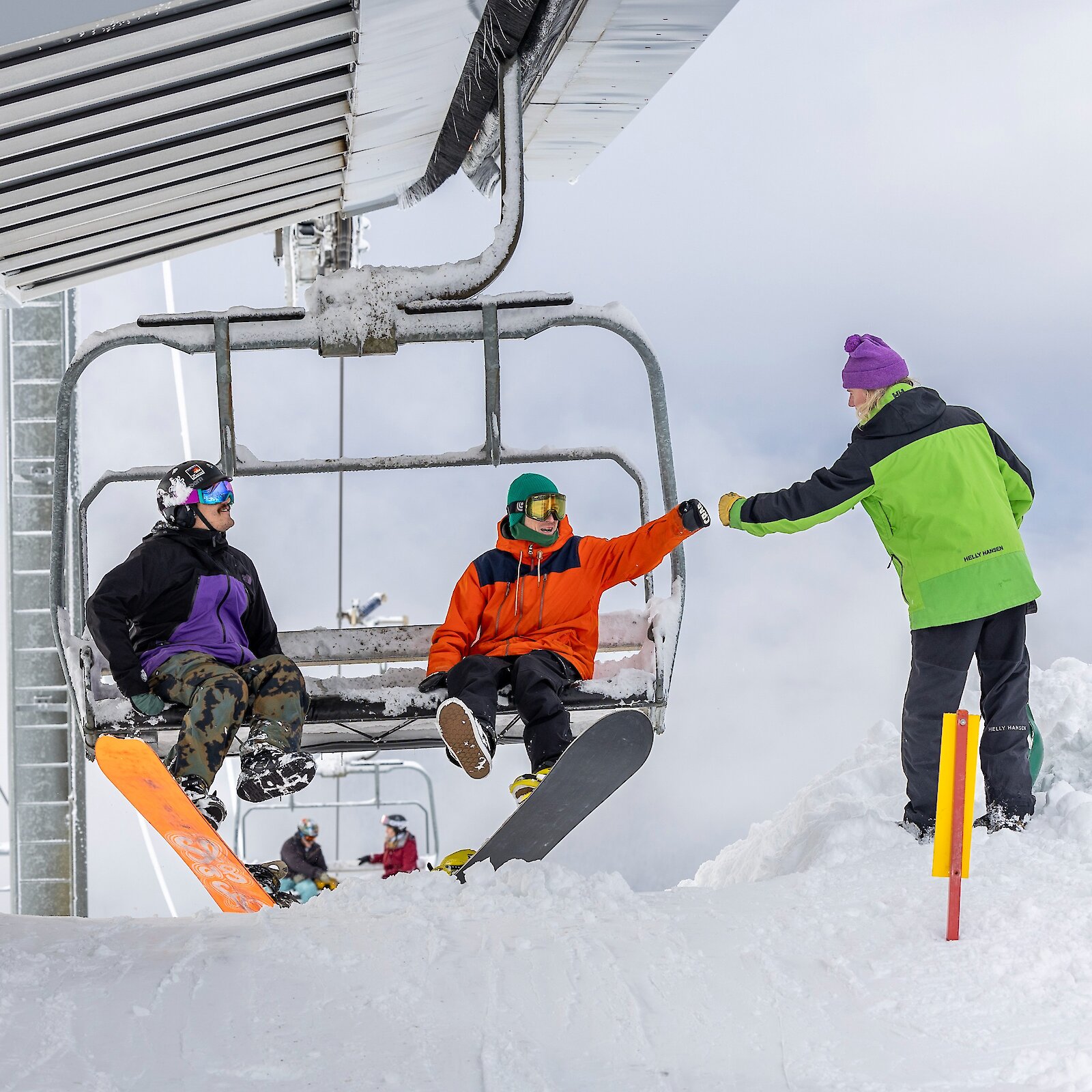 Timberline liftie bumping fists with a snowboarder and a chairlift