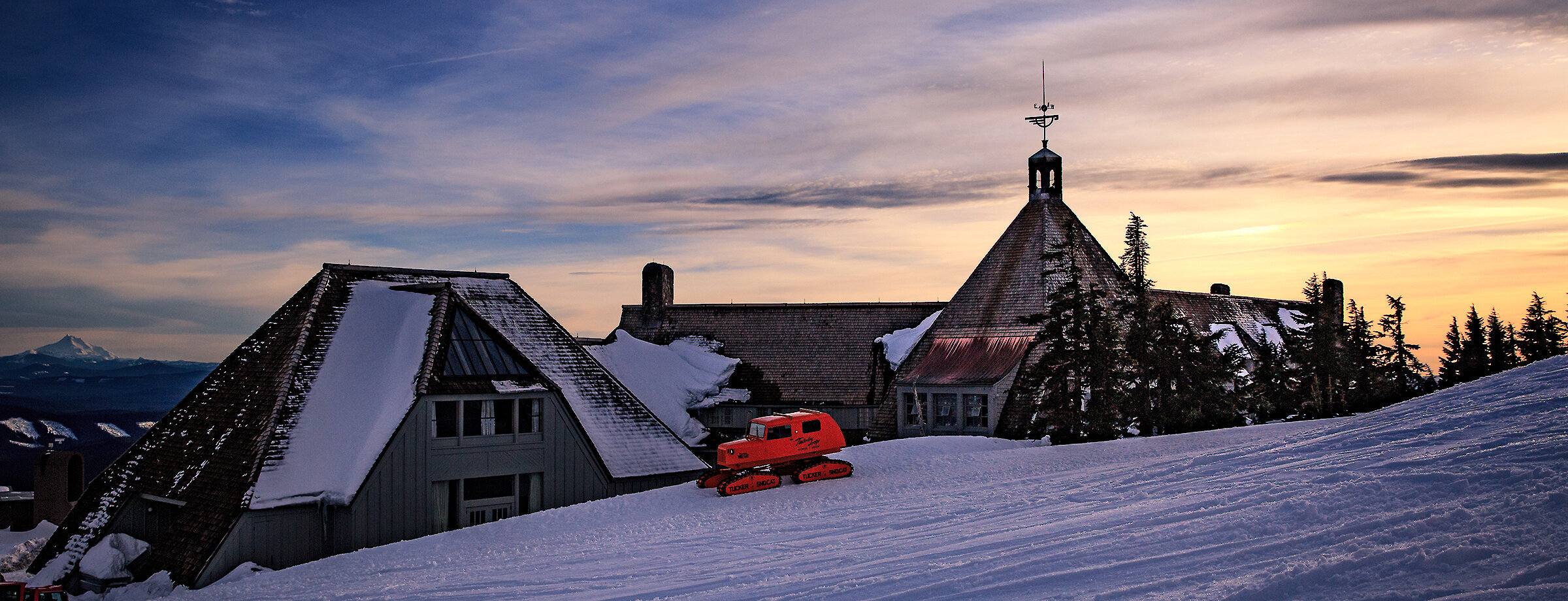 View of Mt. Hood in the summer showing the Magic Mile and Palmer lifts, some snow, skiers, snowboarders, and hikers.