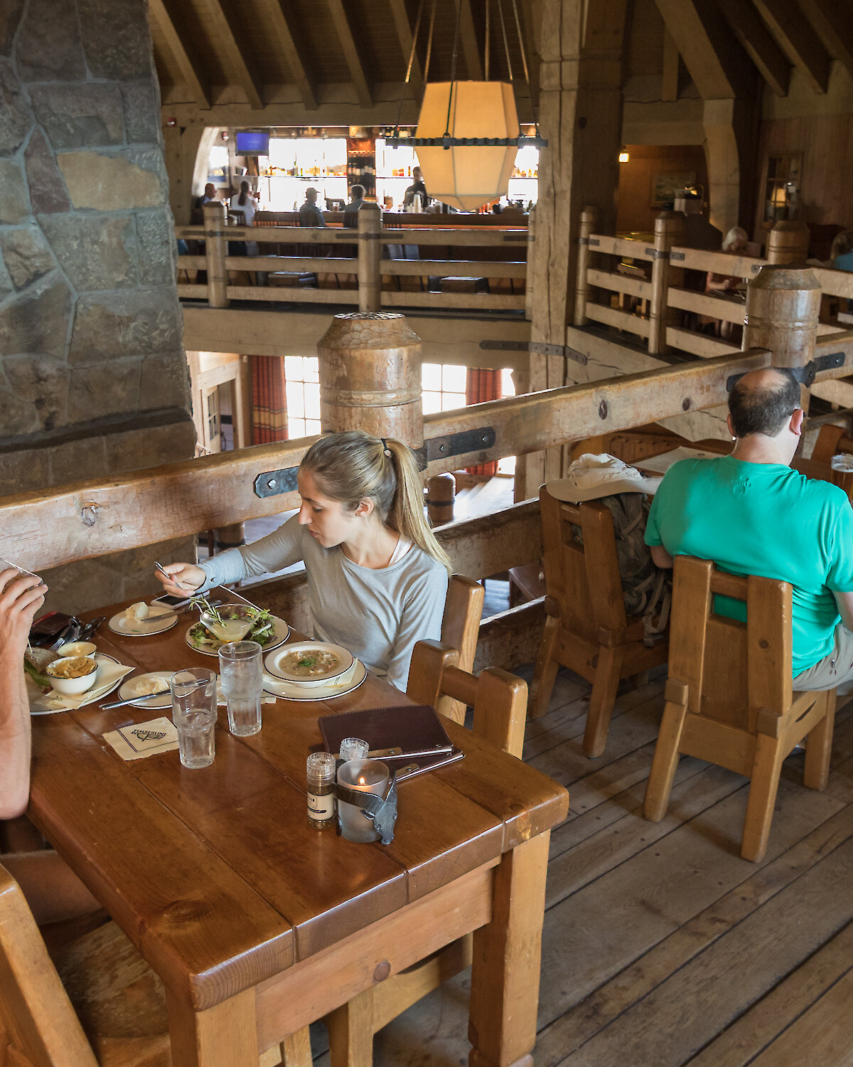 Couples dining around the mezzanine of the Ram's Head Bar, overlooking Timberline's Main Headhouse fireplace.