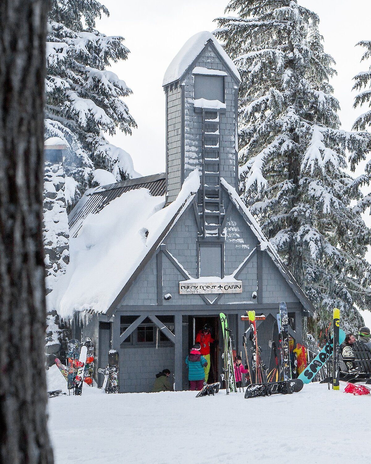 Timberline's Phlox Point Cabin pictured in the winter with skiers and snowboarders mingling outside