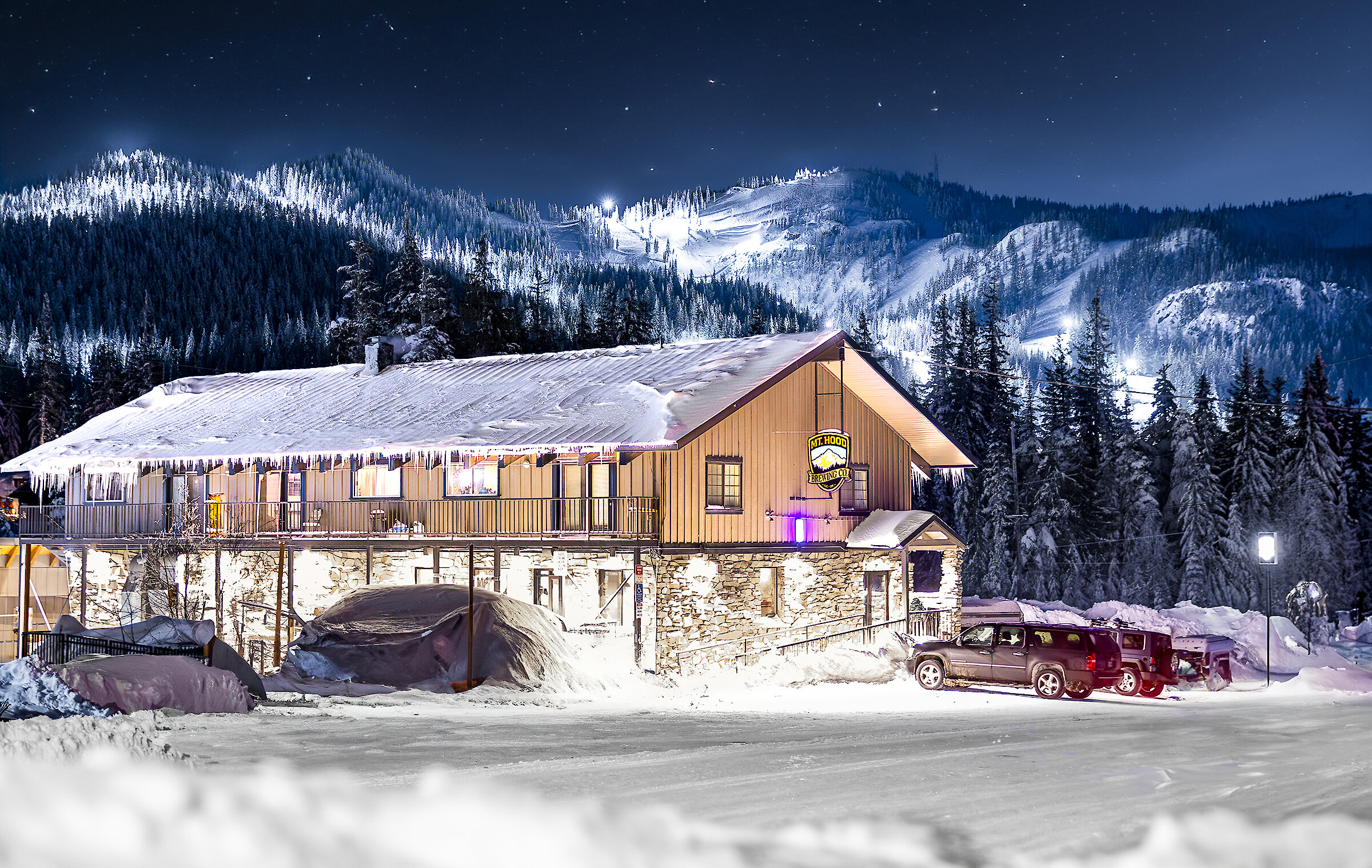 Mt. Hood Brewing Co. brewpub in Government pictured at night in the winter with lit-up Skibowl in the background