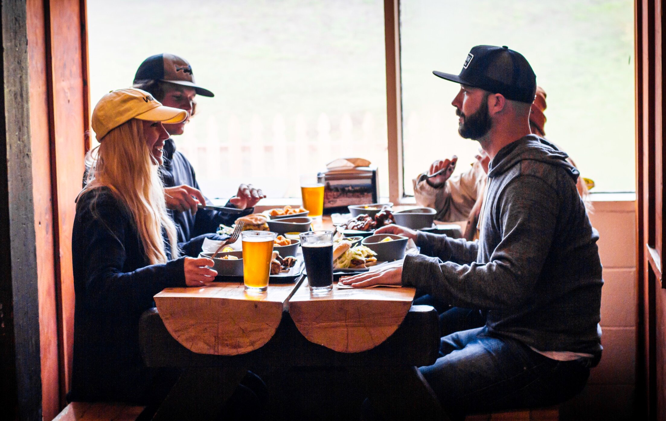 Friends dining at a log table at Summit Pass cafe in Government Camp