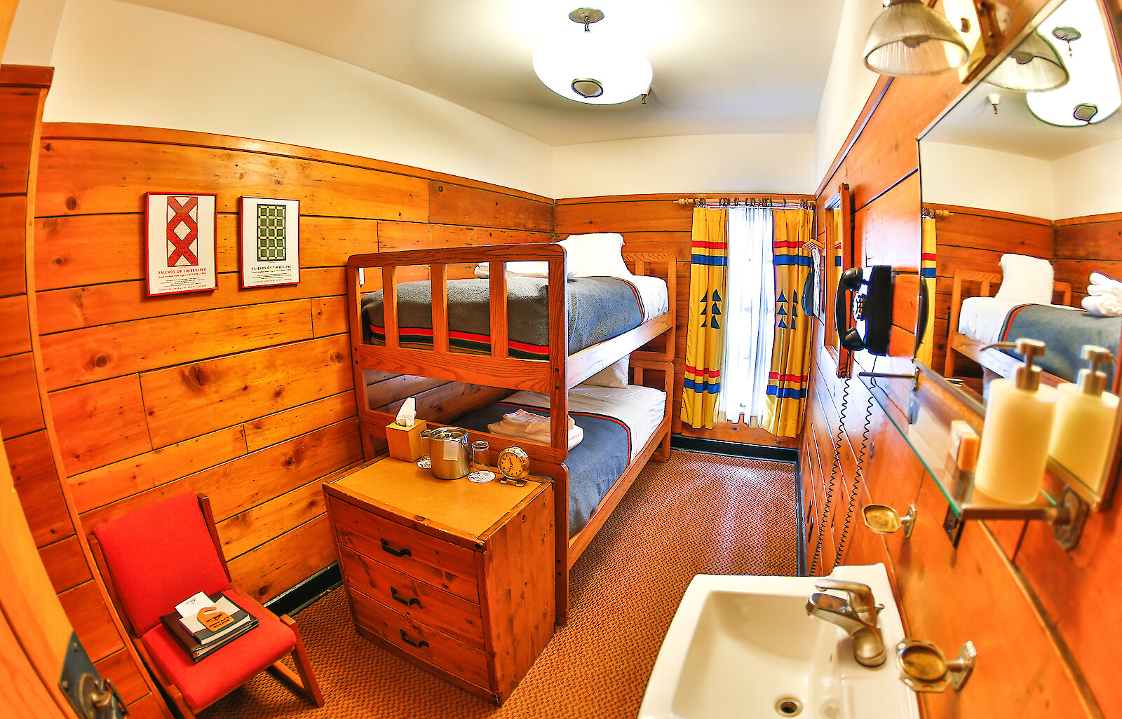 A small chalet room at Timberline Lodge features a bunk bed, sink, shelf, chair, and a window.