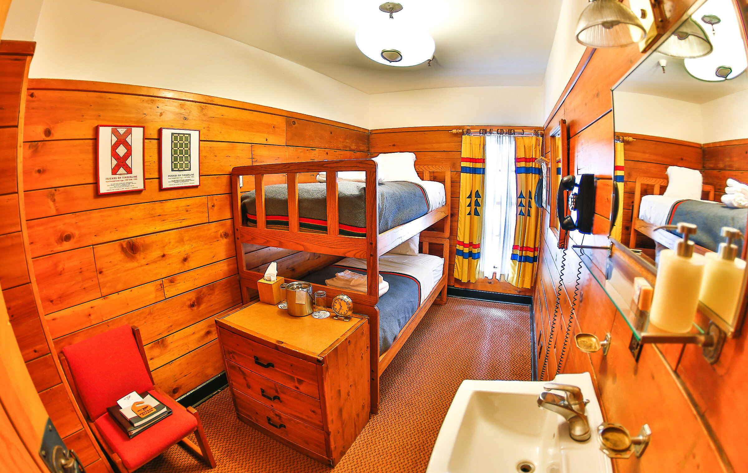 A small chalet room at Timberline Lodge features a bunk bed, sink, shelf, chair, and a window.