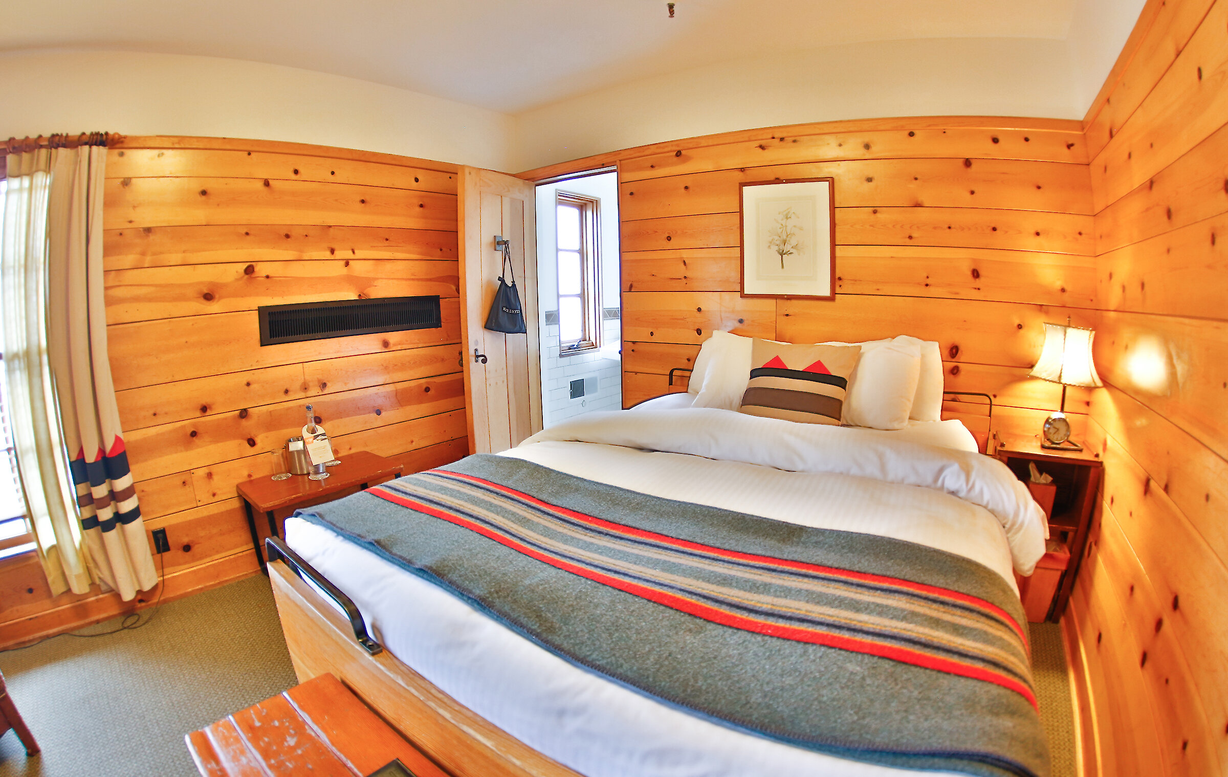 A Timberline queen room pictured with a Pendleton blanket draped over it.