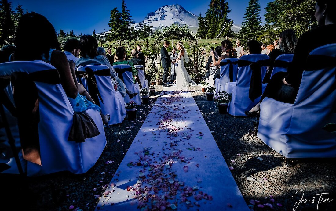 Couple getting married on the back patio at Timberline in the summer with Mt. Hood in the background