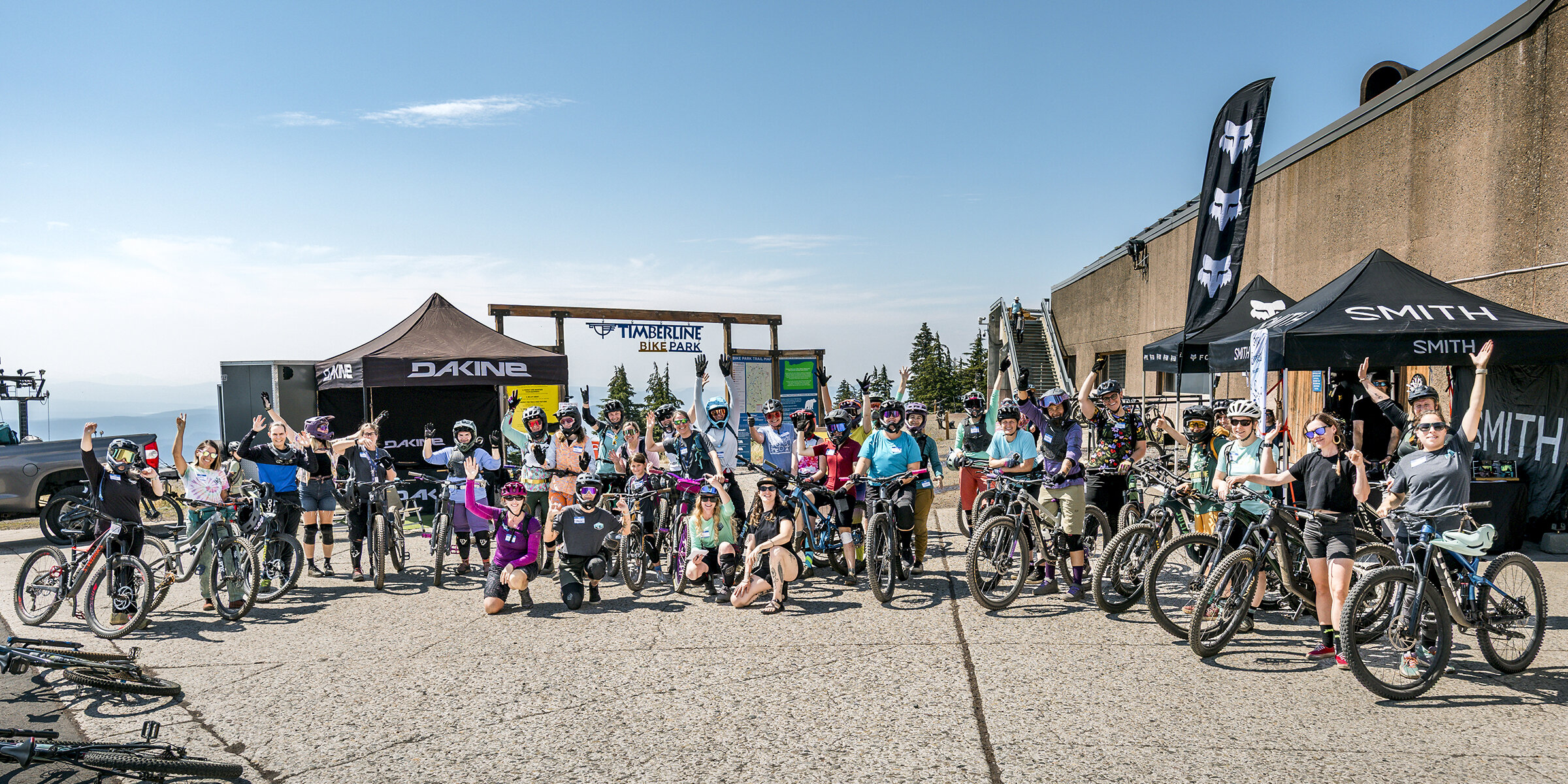 Large group of women mountain bikers posing with their bikes at the timberline bike park trailhead.